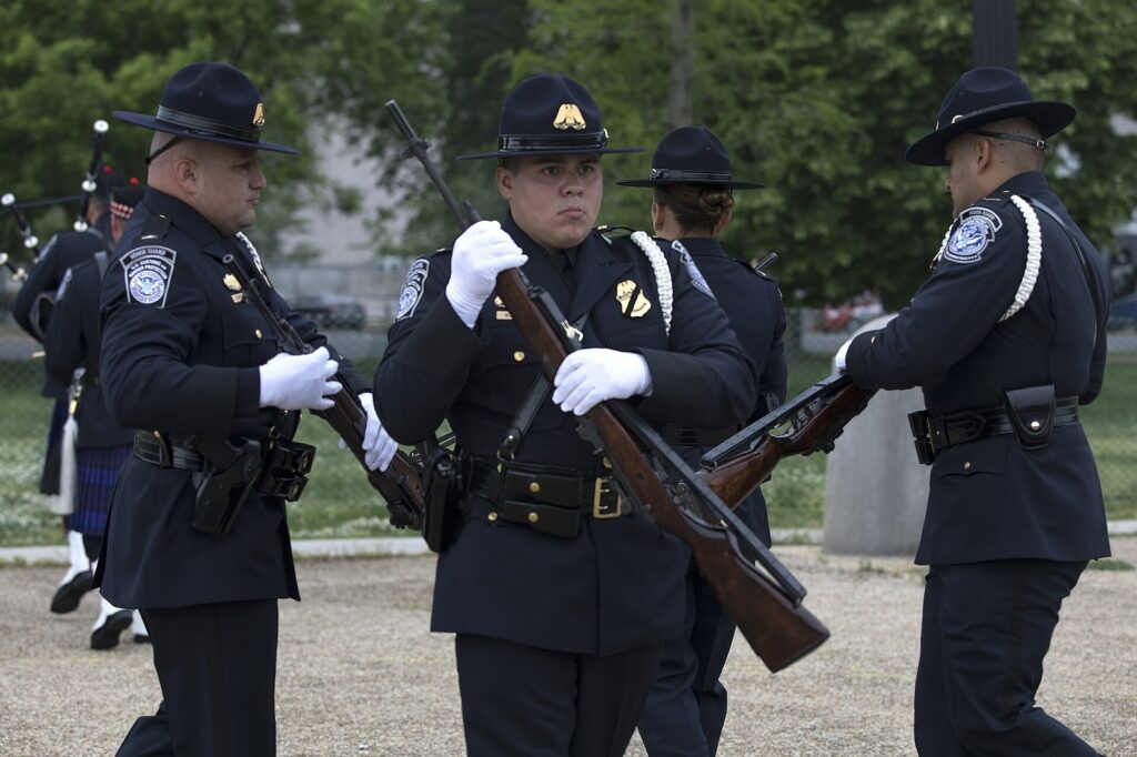 Police honor guard members in dress uniforms with ceremonial rifles